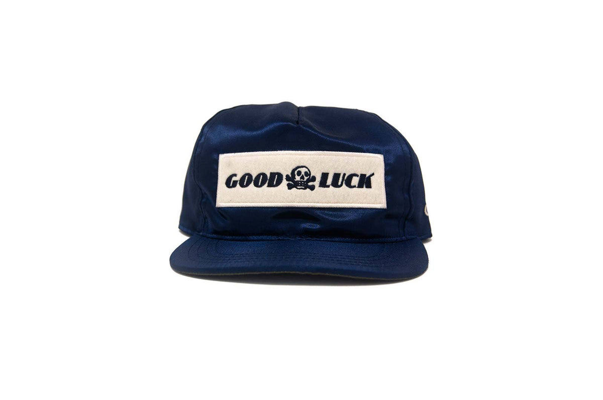 Navy blue cap with 'Good Luck' logo on a white background