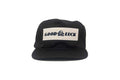 Black cap with 'Good Luck' patch on a white background
