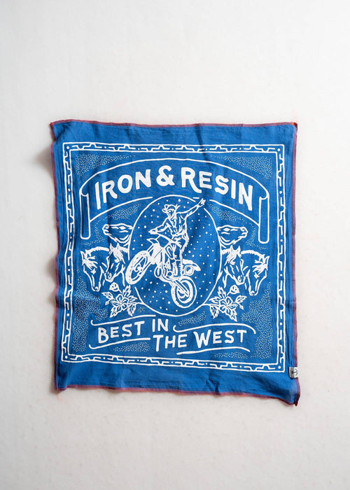 A bandana with a white graphic print featuring a motorcycle rider, wolves, and the text 'IRON & RESIN' and 'BEST IN THE WEST', displayed flat against a light off-white background.