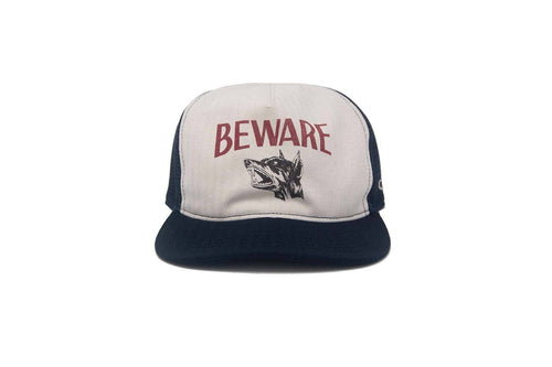 Trucker hat with 'BEWARE' text and wolf graphic on a white background