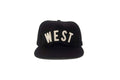 Black cap with 'WEST' printed on it against a white background