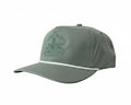 A sage green 5-panel trucker cap with a curved brim, featuring a tonal embroidered mountain and bridge logo with the text 'JUNCTION BENCH' on the front, and a thin white stripe across the brim.