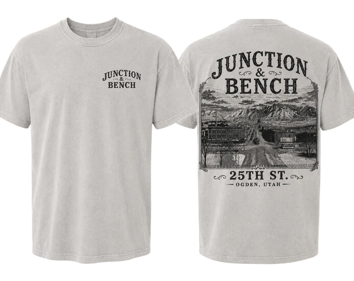 Front and back views of a light gray crewneck t-shirt. The front features a small black graphic on the left chest reading 'JUNCTION BENCH'. The back features a photo of 25th St. Ogden, Utah.