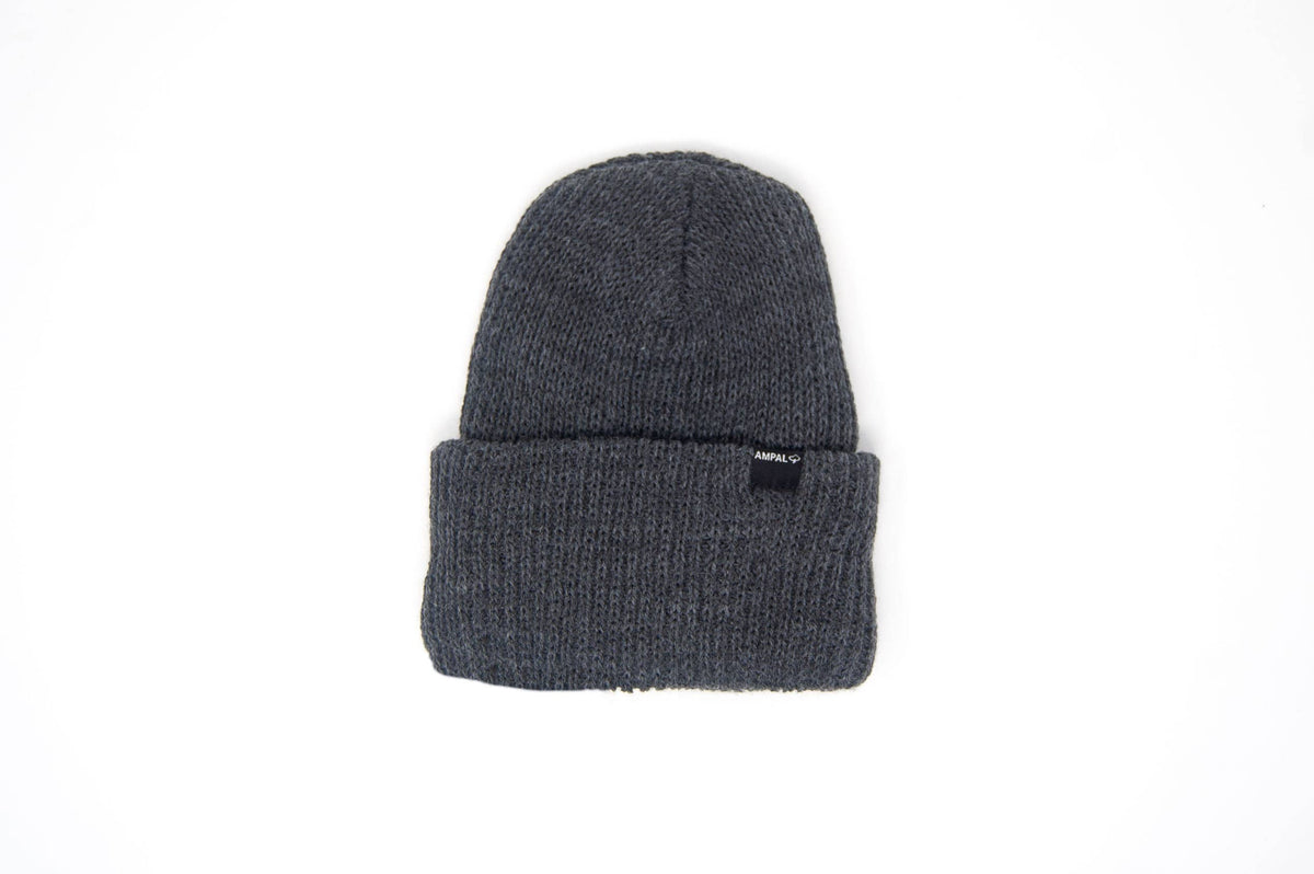 A dark gray ribbed knit beanie hat with a small black brand tag on the front cuff, shown against a plain white background.