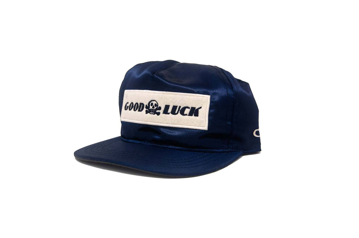 Navy blue cap with 'Good Luck' patch on a white background