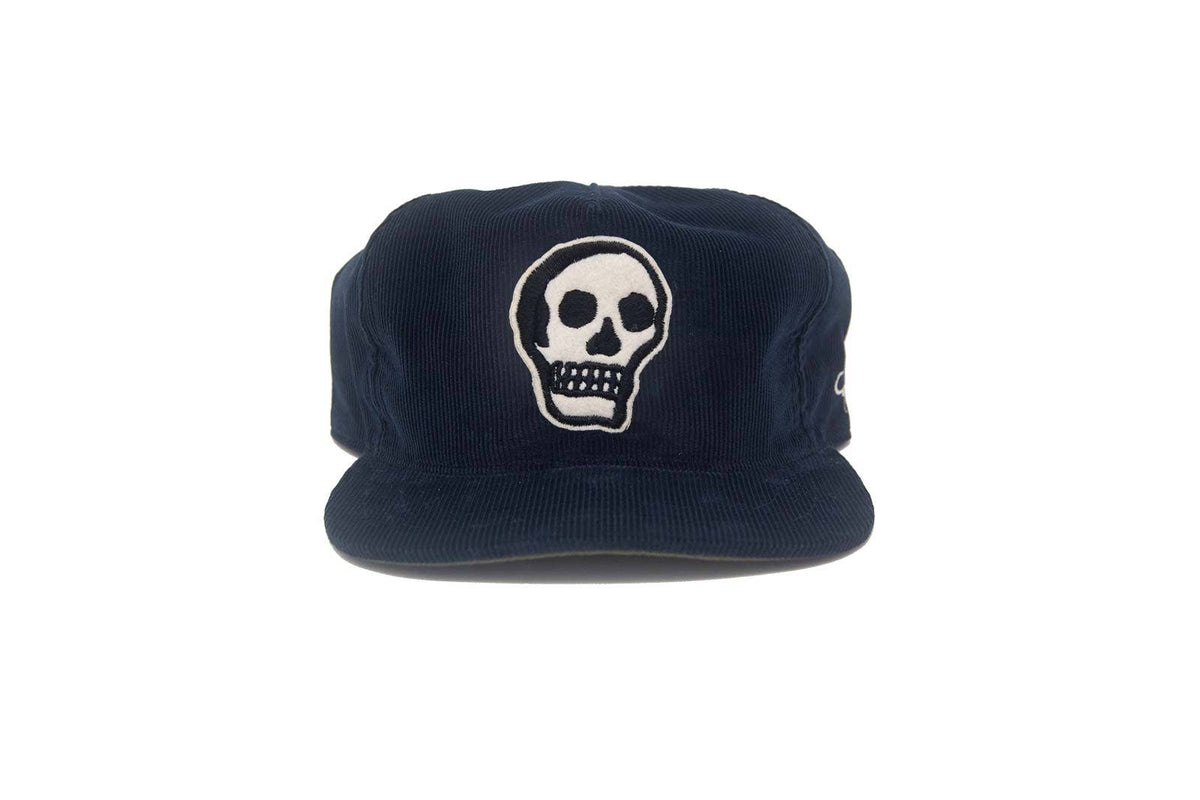 Navy blue cap with a white skull design on a white background
