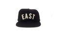 Black cap with 'EAST' printed on it against a white background