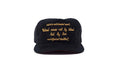 A black snapback cap with gold embroidered text "Hatred ceases not by hatred but by love" on the front panel, displayed against a solid white background.