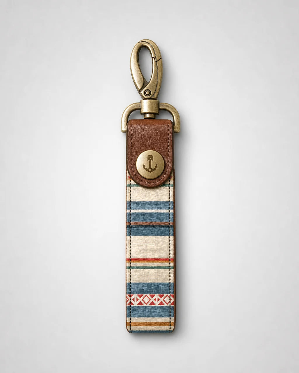 Keychain with striped pattern and brown leather accent on a light gray background